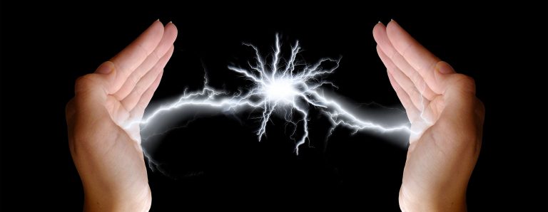 Fotomontage: Zwischen zwei hochgehaltenen Händen entsteht ein Blitz durch elektrische Entladung.